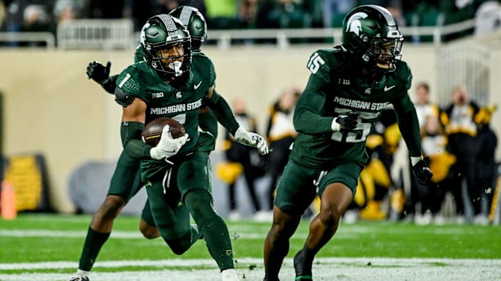 Michigan State's Nikai Martinez, left, returns an interception as Angelo Grose, right, blocks during the fourth quarter in the game against Iowa on Saturday, Oct. 19, 2024, at Spartan Stadium in East Lansing.