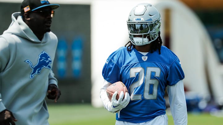 Lions running back Jahmyr Gibbs, right, practices next to running backs coach Scottie Montgomery