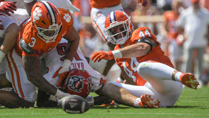 Sep 21, 2024; Clemson, South Carolina, USA; Clemson Tigers defensive end Cade Denhoff (44) looks at a loose ball after defensive end T.J. Parker (3) knocked it out of the hands of North Carolina State Wolfpack University quarterback CJ Bailey (16) during the first quarter at Memorial Stadium.Denhoff recovered the fumble. Sep 21, 2024; Clemson, South Carolina, USA; Clemson Tigers defensive end Cade Denhoff (44) looks at a loose ball after defensive end T.J. Parker (3) knocked it out of the hands of North Carolina State Wolfpack University quarterback CJ Bailey (16) during the first quarter at Memorial Stadium.Denhoff recovered the fumble.