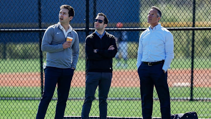 Detroit Tigers chairman and CEO Chris Ilitch, right, president of baseball operations Scott Harris, left, and general manager Jeff Greenberg watch batting practice during spring training at TigerTown in Lakeland, Fla. on Tuesday, Feb. 20, 2024.