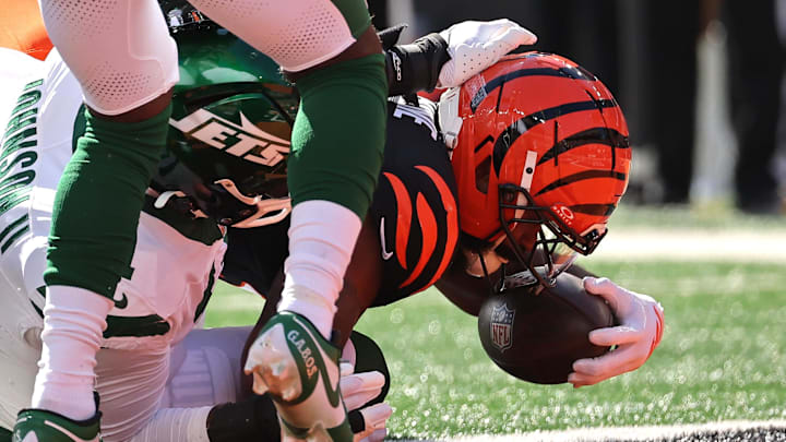 Oct 26, 2025; Cincinnati, Ohio, USA; Cincinnati Bengals running back Samaje Perine (34) falls as New York Jets linebacker Jermaine Johnson (11) plays defense during the first quarter at Paycor Stadium. Mandatory Credit: Joseph Maiorana-Imagn Images