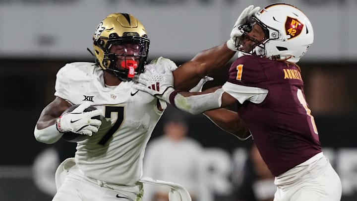 Nov 9, 2024; Tempe, Arizona, USA; UCF Knights running back RJ Harvey (7) delivers a stiff arm to Arizona State Sun Devils defensive back Keith Abney II (1) during the second half at Mountain America Stadium, Home of the ASU Sun Devils. 