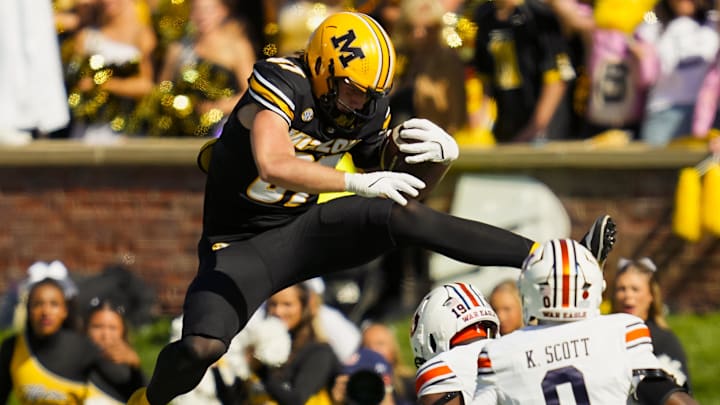 Oct 19, 2024; Columbia, Missouri, USA; Missouri Tigers tight end Brett Norfleet (87) hurdles Auburn Tigers safety Sylvester Smith (19) during the second half at Faurot Field at Memorial Stadium. Mandatory Credit: Jay Biggerstaff-Imagn Images