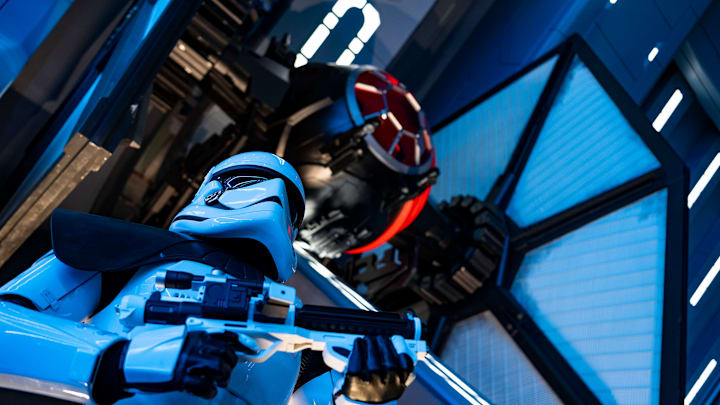 A First Order Stormtrooper stands guard in a Star Destroyer hangar bay beneath a docked TIE fighter in Star Wars: Rise of the Resistance, the groundbreaking new attraction opening Dec. 5, 2019, inside Star Wars: Galaxy’s Edge at Disney’s Hollywood Studios in Florida and Jan. 17, 2020, at Disneyland Park in California. Guests enter the hangar bay after their ship is caught in the Star Destroyer’s tractor beam. (Matt Stroshane, photographer)