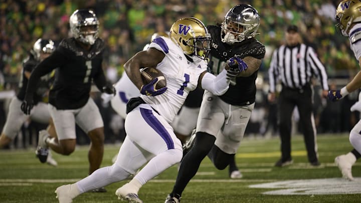 Nov 30, 2024; Eugene, Oregon, USA; Washington Huskies running back Jonah Coleman (1) carries the ball during the first half against Oregon Ducks defensive end Matayo Uiagalelei (10) at Autzen Stadium. Mandatory Credit: Troy Wayrynen-Imagn Images
