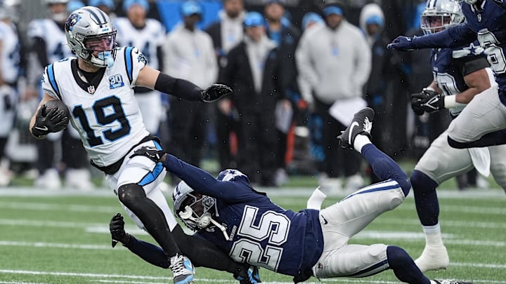 Dec 15, 2024; Charlotte, North Carolina, USA;  Carolina Panthers wide receiver Adam Thielen (19) is tackled by  Dallas Cowboys cornerback Andrew Booth Jr. (25) during the second half at Bank of America Stadium.