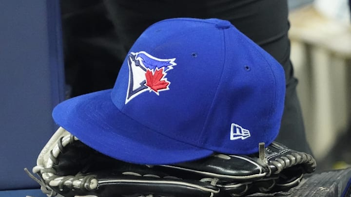 Apr 27, 2024; Toronto, Ontario, CAN; A Toronto Blue Jays hat and glove in the dugout during the third inning against the Los Angeles Dodgers at Rogers Centre. Mandatory Credit: John E. Sokolowski-Imagn Images