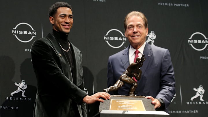 Heisman winner Alabama quarterback Bryce Young poses for pictures with head coach Nick Saban.