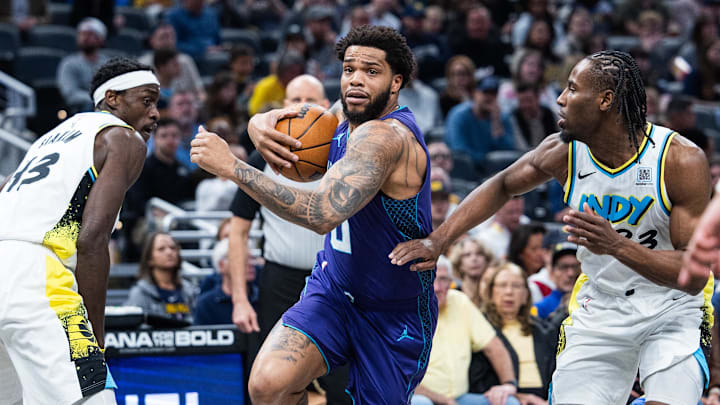 Apr 2, 2025; Indianapolis, Indiana, USA; Charlotte Hornets forward Miles Bridges (0) drives against Indiana Pacers forward Aaron Nesmith (23) in the first half at Gainbridge Fieldhouse. Mandatory Credit: Trevor Ruszkowski-Imagn Images