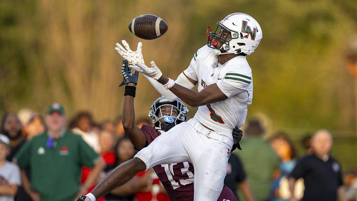 Lawrence North High School sophomore Monshun Sales (1) makes a catch in the end zone to score while being defended by Lawrence Central High School junior DJ Summers (13) during the first half of an IHSAA varsity football game, Friday, Aug. 23, 2024, at Lawrence Central High School.
