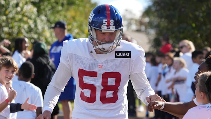 Oct 7,, 2022; Thundridge, United Kingdom; New York Giants long snapper Casey Kreiter (58) is greeted by children during practice at Hanbury Manor.  