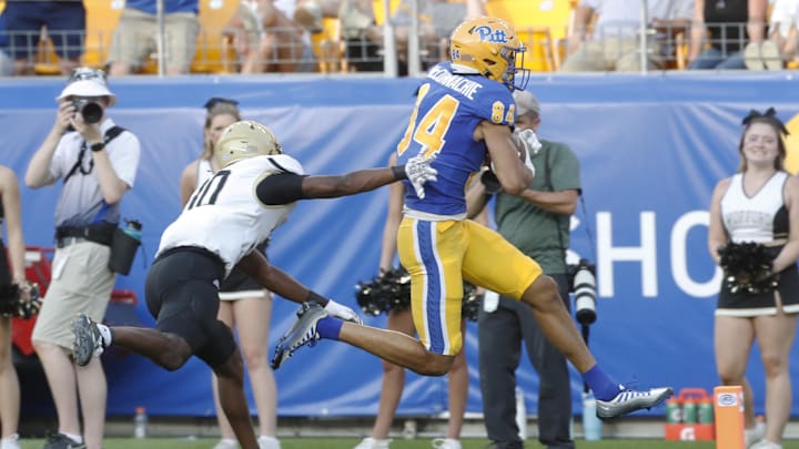 Sep 2, 2023; Pittsburgh, Pennsylvania, USA;  Pittsburgh Panthers wide receiver Jake McConnachie (84) scores a touchdown ahead of Wofford Terriers defensive back Eli Campbell (30) during the fourth quarter at Acrisure Stadium. Pittsburgh won 45-7. Mandatory Credit: Charles LeClaire-Imagn Images