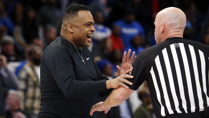Feb 4, 2023; Memphis, Tennessee, USA; Tulane Green Wave head coach Ron Hunter (left) talks with an official during a timeout during the second half against the Memphis Tigers at FedExForum.
