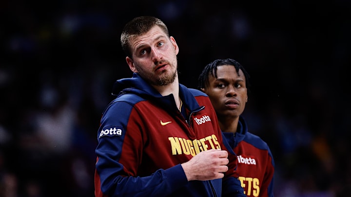 Apr 1, 2025; Denver, Colorado, USA; Denver Nuggets center Nikola Jokic (15) and forward Peyton Watson (8) look on from the sideline in the second quarter against the Minnesota Timberwolves at Ball Arena. Mandatory Credit: Isaiah J. Downing-Imagn Images