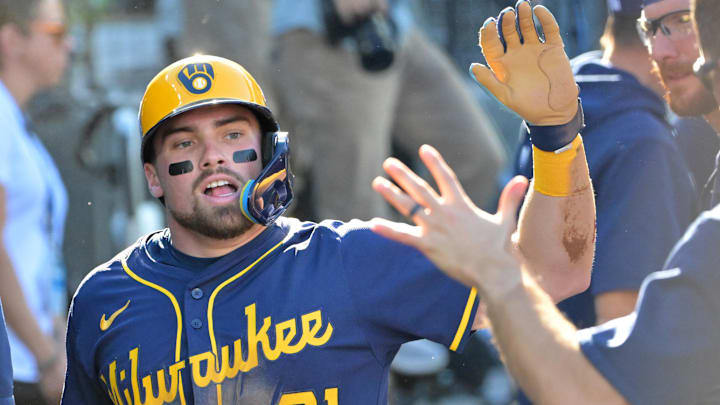 Oct 16, 2025; Los Angeles, California, USA; Milwaukee Brewers third baseman Caleb Durbin (21) celebrates in the dugout after scoring against the Los Angeles Dodgers in the second inning during game three of the NLCS round for the 2025 MLB playoffs at Dodger Stadium. Mandatory Credit: Jayne Kamin-Oncea-Imagn Images