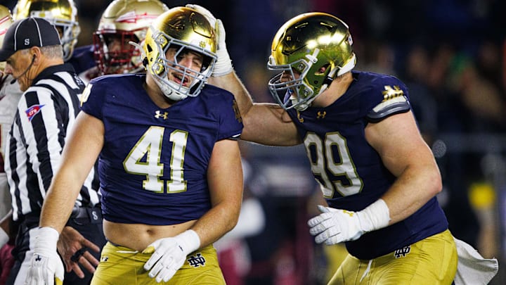 Notre Dame defensive lineman Rylie Mills (99) and defensive lineman Donovan Hinish (41) celebrate getting a stop during a NCAA college football game against Florida State at Notre Dame Stadium on Saturday, Nov. 9, 2024, in South Bend.