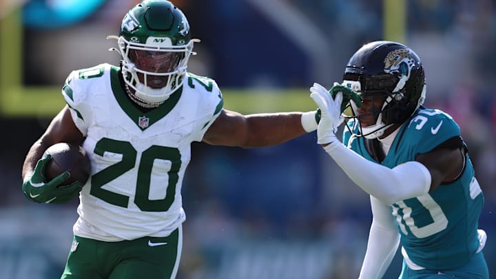 Dec 14, 2025; Jacksonville, Florida, USA; New York Jets running back Breece Hall (20) runs with the ball against Jacksonville Jaguars cornerback Montaric Brown (30) during the first quarter at EverBank Stadium. 