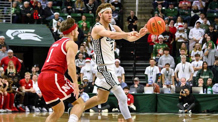 Dec 7, 2024; East Lansing, Michigan, USA;  Michigan State Spartans guard Gehrig Normand (7) passes to a teammate in front of Nebraska Cornhuskers guard Sam Hoiberg (1) during the second half at Jack Breslin Student Events Center. Mandatory Credit: Dale Young-Imagn Images