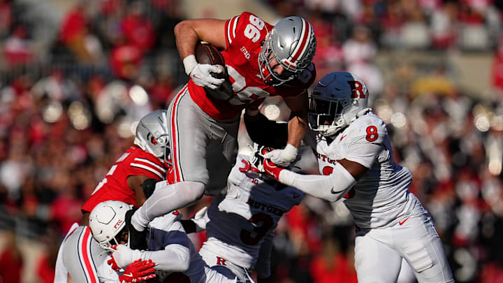 Ohio State Buckeyes tight end Max Klare (86) hurdles Rutgers Scarlet Knights defensive back Bo Mascoe (3), defensive back Kaj Sanders (5) and linebacker Dariel Djabome (8) during the second half of the NCAA football game at Ohio Stadium in Columbus on Nov. 22, 2025. Ohio State won 42-9.