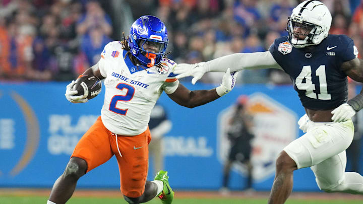 Boise State Broncos running back Ashton Jeanty (2) runs past Penn State Nittany Lions linebacker Kobe King (41) during their Vrbo Fiesta Bowl matchup at State Farm Stadium on Dec. 31, 2024.