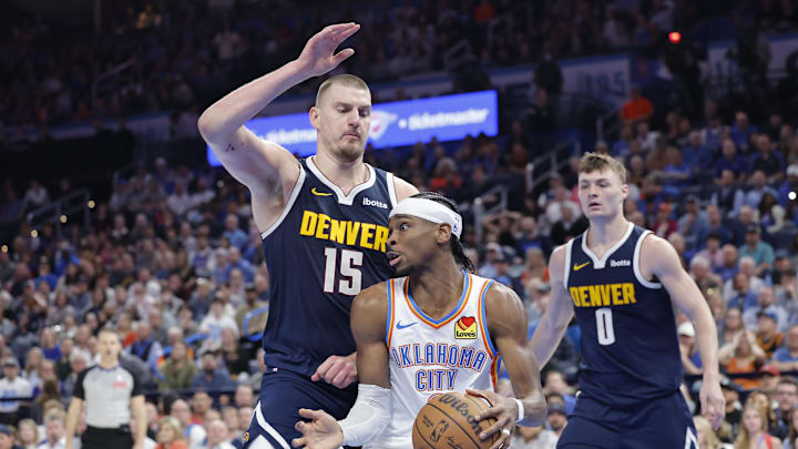 Mar 10, 2025; Oklahoma City, Oklahoma, USA; Denver Nuggets center Nikola Jokic (15) defends a drive by Oklahoma City Thunder guard Shai Gilgeous-Alexander (2) during the second half at Paycom Center. Mandatory Credit: Alonzo Adams-Imagn Images
