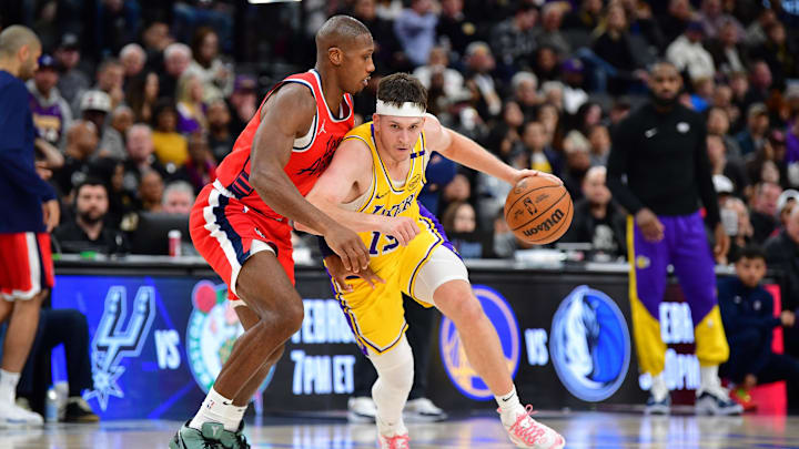 Feb 4, 2025; Inglewood, California, USA; Los Angeles Lakers guard Austin Reaves (15) moves the ball against Los Angeles Clippers guard Kris Dunn (8) during the second half at Intuit Dome. Mandatory Credit: Gary A. Vasquez-Imagn Images