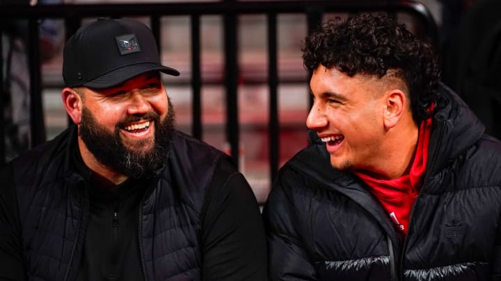 Jan 3, 2024; Lincoln, Nebraska, USA; Nebraska Cornhuskers football assistant coach Donovan Raiola (left) and Dylan Raiola smile before the game against the Indiana Hoosiers at Pinnacle Bank Arena. Dylan is the top quarterback recruit in the 2024 class.