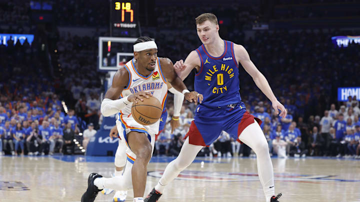 May 13, 2025; Oklahoma City, Oklahoma, USA; Oklahoma City Thunder guard Shai Gilgeous-Alexander (2) drives to the basket beside Denver Nuggets guard Christian Braun (0) during the second half of game five of the second round for the 2025 NBA Playoffs at Paycom Center. Mandatory Credit: Alonzo Adams-Imagn Images