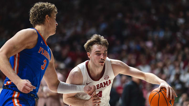 Mar 5, 2025; Tuscaloosa, Alabama, USA; Alabama Crimson Tide forward Grant Nelson (4) drives the ball against Florida Gators center Micah Handlogten (3) during the second half at Coleman Coliseum. Mandatory Credit: Will McLelland-Imagn Images