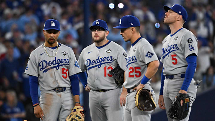 Oct 24, 2025; Toronto, Ontario, CAN; Los Angeles Dodgers shortstop Mookie Betts (50), third baseman Max Muncy (13), second baseman Tommy Edman (25) and first baseman Freddie Freeman (5) look on during a pitching change against the Toronto Blue Jays in the sixth inning during game one of the 2025 MLB World Series at Rogers Centre. Mandatory Credit: Dan Hamilton-Imagn Images