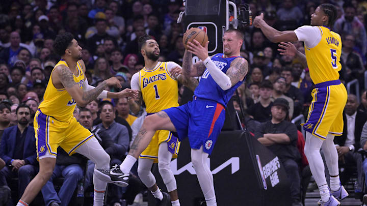 Jan 23, 2024; Los Angeles, California, USA; Los Angeles Clippers center Daniel Theis (10) is surrounded by Los Angeles Lakers forward Christian Wood (35), guard D'Angelo Russell (1) and forward Cam Reddish (5) as he holds on to a rebound in the second half at Crypto.com Arena. Mandatory Credit: Jayne Kamin-Oncea-Imagn Images
