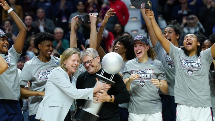 Mar 11, 2024; Uncasville, CT, USA; UConn Huskies head coach Geno Auriemma is handed the Big East trophy. Mar 11, 2024; Uncasville, CT, USA; UConn Huskies head coach Geno Auriemma is handed the Big East trophy.