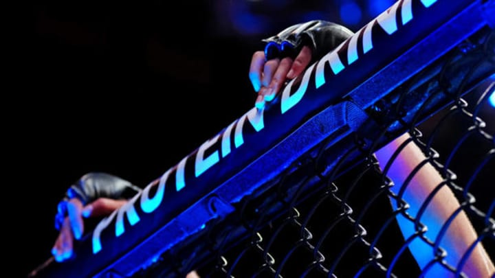 UFC fighter's hands on the cage.