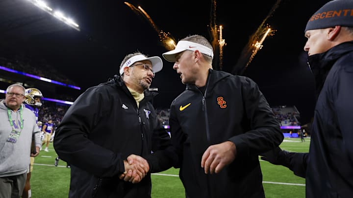 Nov 2, 2024; Seattle, Washington, USA; Washington Huskies head coach Jedd Fisch, left, shakes hands with USC Trojans head coach Lincoln Riley following a Washington victory at Alaska Airlines Field at Husky Stadium. Mandatory Credit: Joe Nicholson-Imagn Images