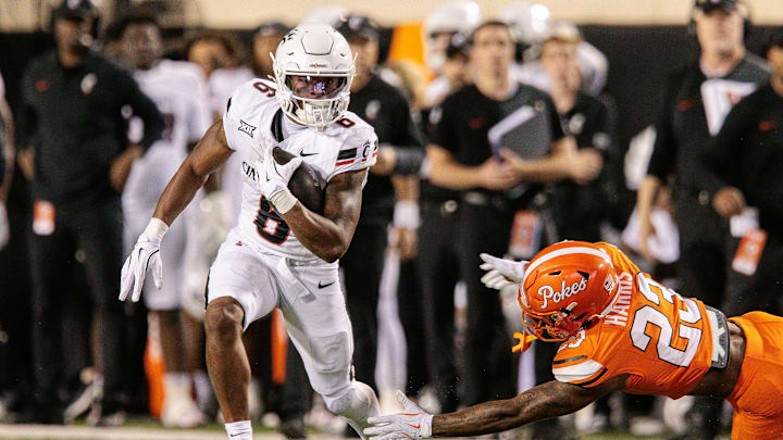 Oct 18, 2025; Stillwater, Oklahoma, USA; Cincinnati Bearcats running back Evan Pryor (6) runs the ball around Oklahoma State Cowboys safety Kenneth Harris (23) during the first half at Boone Pickens Stadium. Mandatory Credit: William Purnell-Imagn Images