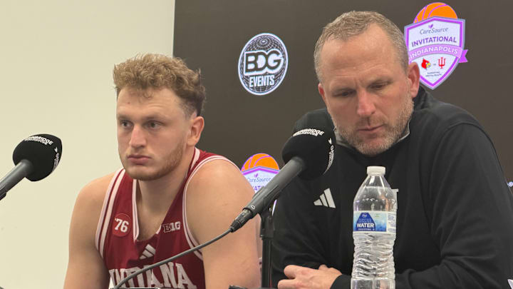 Indiana basketball forward Tucker DeVries (left) and coach Darian DeVries (right) speak to reporters Dec. 6, 2025, at Gainbridge Fieldhouse in Indianapolis. Indiana basketball forward Tucker DeVries (left) and coach Darian DeVries (right) speak to reporters Dec. 6, 2025, at Gainbridge Fieldhouse in Indianapolis.