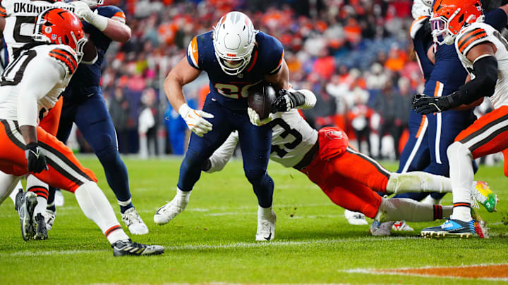 Dec 2, 2024; Denver, Colorado, USA; Denver Broncos fullback Michael Burton (20) scores a touchdown past Cleveland Browns linebacker Mohamoud Diabate (43) in the second quarter at Empower Field at Mile High. Mandatory Credit: Ron Chenoy-Imagn Images