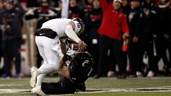 Nov 30, 2024; Cincinnati, Ohio, USA; TCU Horned Frogs quarterback Josh Hoover (10) slips a sack attempt by Cincinnati Bearcats linebacker Jack Dingle (49) in the first quarter at Nippert Stadium. Mandatory Credit: Albert Cesare/USA TODAY Network via Imagn Images Nov 30, 2024; Cincinnati, Ohio, USA; TCU Horned Frogs quarterback Josh Hoover (10) slips a sack attempt by Cincinnati Bearcats linebacker Jack Dingle (49) in the first quarter at Nippert Stadium. Mandatory Credit: Albert Cesare/USA TODAY Network via Imagn Images