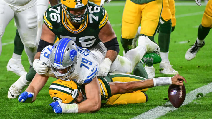 Green Bay Packers quarterback Jordan Love (10) tackled by Detroit Lions John Cominsky