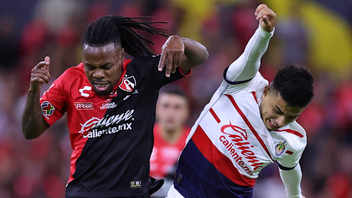 El venezolano Jhon Murillo del Atlas y Fernando Beltrán de Chivas luchan por el esférico en el Clásico Tapatío del Clausura 2024