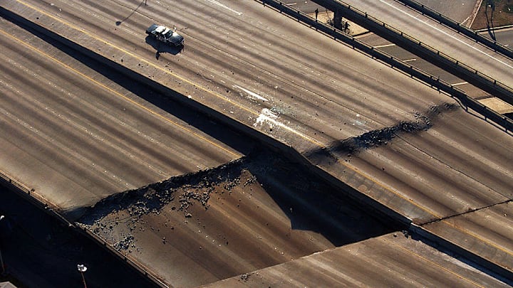 A police car guards a section of a Los Angeles freeway cracked by the magnitude 6.7 Northridge earthquake in 1994.