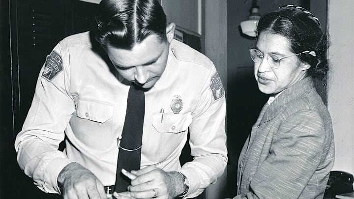 Rosa Parks is fingerprinted by a Montgomery, Alabama, police officer after being arrested for refusing to give up her bus seat to a white passenger.