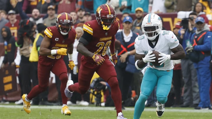 Miami Dolphins wide receiver Tyreek Hill catches a touchdown pass as Washington Commanders safety Jartavius Martin (20) chases during the first quarter at FedExField last season.
