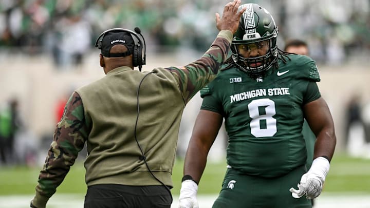 Michigan State's interim head coach Harlon Barnett, left, pats Simeon Barrow Jr. on the helmet during the first quarter in the game against Nebraska on Saturday, Nov. 4, 2023, at Spartan Stadium in East Lansing.