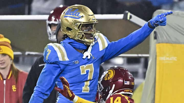 Nov 23, 2024; Pasadena, California, USA; UCLA Bruins wide receiver J.Michael Sturdivant (7) signals a first down after catching a long pass over USC Trojans cornerback Jacobe Covington (14) in the third quarter at Rose Bowl. Mandatory Credit: Robert Hanashiro-Imagn Images