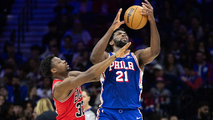 Jan 2, 2024; Philadelphia, Pennsylvania, USA; Philadelphia 76ers center Joel Embiid (21) and Chicago Bulls forward Terry Taylor (32) reach for a loose ball during the third quarter at Wells Fargo Center. Mandatory Credit: Bill Streicher-Imagn Images