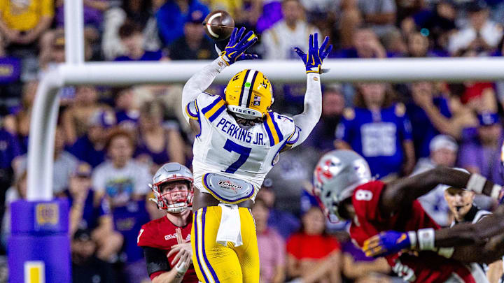 Sep 7, 2024; Baton Rouge, Louisiana, USA; Nicholls State Colonels quarterback Pat McQuaide (7) rolls out of the pocket against LSU Tigers linebacker Harold Perkins Jr. (7) during the second half at Tiger Stadium. Mandatory Credit: Stephen Lew-Imagn Images
