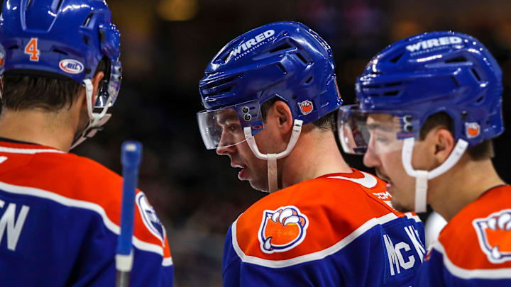 Bakersfield forward Greg McKegg (14) talks with defenseman Cam Dineen (4) and other teammates during