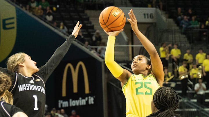 Oregon’s Deja Kelly, center, shots over Washington’s Hannah Stines during the second half at Matthew Knight Arena Wednesday, Feb. 12, 2025.