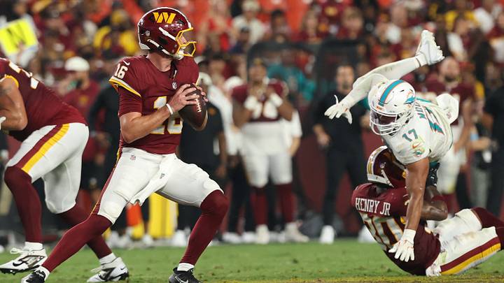 Aug 14, 2026; Landover, Maryland, USA; Washington Commanders quarterback Athan Kaliakmanis (16) drops back to pass as Miami Dolphins linebacker Trey Moore (17) rushes during the second half at Northwest Stadium. Mandatory Credit: Geoff Burke-Imagn Images